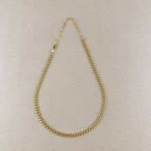Load image into Gallery viewer, A delicate gold chain necklace with a small lobster clasp, displayed on a textured beige fabric background.