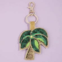 Load image into Gallery viewer, A green and gold beaded palm tree keychain with a light blue background