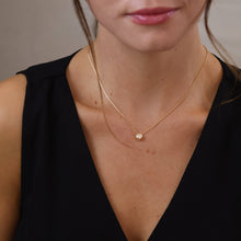 Load image into Gallery viewer, Woman wearing a delicate gold necklace with a small pendant against a neutral background