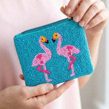 Load image into Gallery viewer, a beaded coin purse with two pink flamingos and a blue background being held by a person wearing a light pink shirt