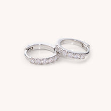 Load image into Gallery viewer, Two silver hoop earrings with embedded cz stones on a white background