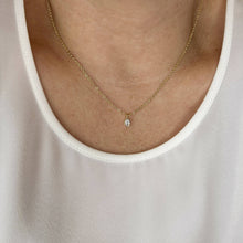 Load image into Gallery viewer, Gold necklace with a small pendant worn by a person in a white tank top.