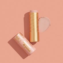 Load image into Gallery viewer, A pink and gold Farrah lip balm stick product labeled 'Poppy & Pout' with a matching cap placed beside it, alongside a circular swatch of the pressed powder on a peach-pink background.