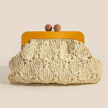 Load image into Gallery viewer, An ivory-colored crocheted clutch with an open-knit pattern and a wooden frame closure featuring two round wooden knobs, displayed against a white background.