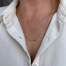 Load image into Gallery viewer, Gold necklace with engraved text worn by a person in a white shirt.