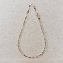 Load image into Gallery viewer, Gold chain necklace on a textured beige surface
