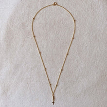 Load image into Gallery viewer, Necklace with a cross pendant on a beige fabric background
