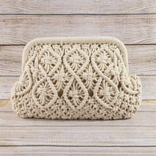 Load image into Gallery viewer, Cream-colored macrame clutch bag featuring an intricate floral land diamond-patterned woven design with a textured braid border. Placed in front of a white wood background.
