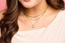 Load image into Gallery viewer, Close-up of a person wearing multiple necklaces with heart pendants against a pink background
