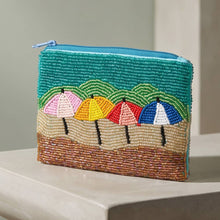 Load image into Gallery viewer, A beaded coin purse with 4 colorful umbrellas on it on a grey counter with a grey background
