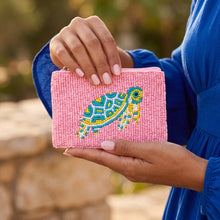 Load image into Gallery viewer, A pink beaded coin purse with a blue, white and yellow turtle on it.  A woman in a blue dress is holding it 
