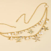 Load image into Gallery viewer, A gold-tone layered waist chain featuring seashel, pearl, starfish, and beach-inspired charms laying on a white background. 
