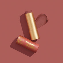 Load image into Gallery viewer, Poppy &amp; Pout Debbie lip tint with gold cap and red casing on a maroon background
