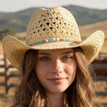 Load image into Gallery viewer, A woman with mountains and a fence in the background wearing an ivory cowboy hat with a beaded hat band 
