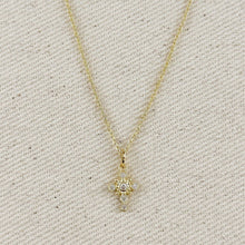 Load image into Gallery viewer, A gold cross pendant necklace adorned with clear gemstones, suspended from a gold chain against a plain white background.
