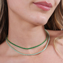 Load image into Gallery viewer, Close-up of a woman wearing two green beaded necklaces.
