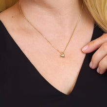 Load image into Gallery viewer, Gold necklace with a heart pendant on a person wearing a black top.
