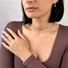 Load image into Gallery viewer, Woman wearing a gold necklace, ring, and bracelet against a neutral background
