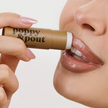 Load image into Gallery viewer, Person applying 'poppy &amp; pout' vanilla cha lip balm to their lips with a white background

