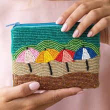 Load image into Gallery viewer, Beaded coin purse with 4 colorful umbrellas held by a woman with pink nails and a pink shirt

