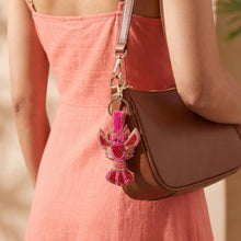 Load image into Gallery viewer, Woman in a pink dress holding a brown purse with a pink and red lobster key chain 
