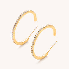 Load image into Gallery viewer, Gold and shimmering cz stone hoop earrings with a white background
